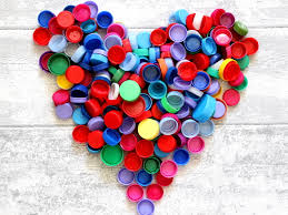 Photo de bouchons d'amour de toutes les couleurs réunis en forme d'un grand coeur